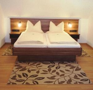 a bedroom with two beds and a rug at Hotel Landgasthof Euringer in Oberstimm