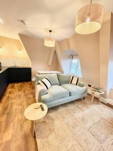 ein Wohnzimmer mit einem blauen Sofa und einem Tisch in der Unterkunft Redland Suites - Apartment 7 in Bristol