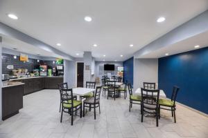 a dining room with tables and chairs and a kitchen at Quality Inn Fort Stockton in Fort Stockton