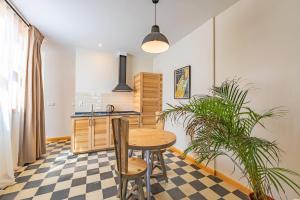 een keuken met een tafel en stoelen en een plant bij New Use Pz España 3 izquierda in Cádiz
