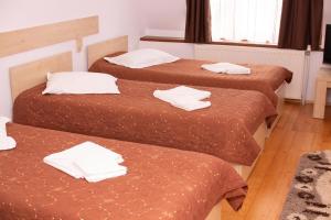 - 3 lits dans une chambre d'hôtel avec des serviettes blanches dans l'établissement Bicaz-Chei, à Bicaz-Chei