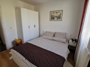 a bedroom with a bed and a white cabinet at Apartman Selma in Vinine