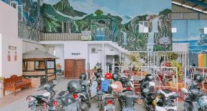 un groupe de motocycles garés devant un bâtiment orné d'une fresque murale dans l'établissement RedDoorz @ Tongas Probolinggo, à Pesisir