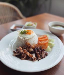 a plate of food with rice and vegetables on a table at Lavanya Boutique Hotel in Phnom Penh