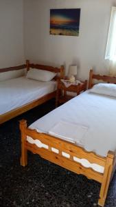 two beds in a room with two tables at Nature of Karapata in Koroni