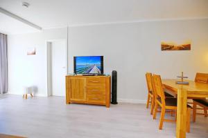 ein Esszimmer mit einem Tisch und einem TV auf einem Schrank in der Unterkunft Sünnslag Wohnung 054 in Boltenhagen