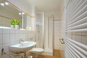 a white bathroom with a sink and a toilet at Dünenblick Wohnung 51 in Boltenhagen