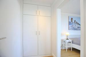 a white closet in a bedroom with a bed at Dünenblick Wohnung 51 in Boltenhagen