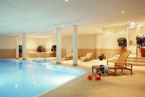a pool in a hotel with a dog sitting next to it at Residenz Bismarck, Whg 19 in Westerland (Sylt)