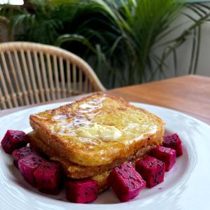 a white plate with a piece of toast and red cubes at Lavanya Boutique Hotel in Phnom Penh