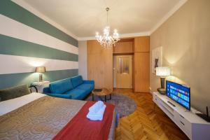 プラハにあるDlouhá Apartment with balconyのベッドルーム(ベッド1台、青いソファ付)