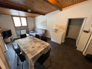 ein Wohnzimmer mit einem Tisch und einem Sofa in der Unterkunft Appartement en hyper centre in Le Mont-Dore