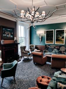 a living room with a couch and a chandelier at Makeney Hall Hotel in Derby