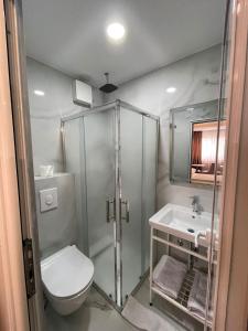 a bathroom with a shower and a toilet and a sink at Freddy's Hotel in Tirana