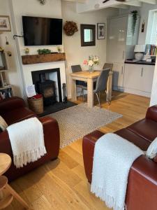 a living room with a fireplace and a table at Lavender Cottage in Ripon