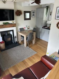 a living room with a table and a fireplace at Lavender Cottage in Ripon