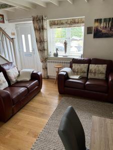 - un salon avec deux canapés en cuir et une fenêtre dans l'établissement Lavender Cottage , Grewelthorpe , nr Masham, à Grewelthorpe 60 autres photos