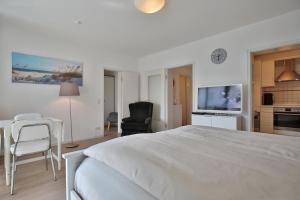 een witte slaapkamer met een groot bed en een keuken bij Am Elchgrund Am Elchgrund 7 Appartement 2 in Timmendorfer Strand