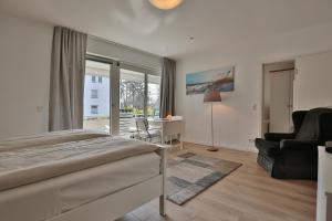 een slaapkamer met een bed en een woonkamer bij Am Elchgrund Am Elchgrund 7 Appartement 2 in Timmendorfer Strand