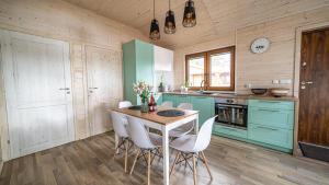 a kitchen with blue cabinets and a table and chairs at Słoneczny Domek Borsk nr 2 i 15 in Borsk