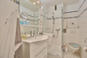 La salle de bains est pourvue d'un lavabo, d'une douche et de toilettes. dans l'établissement Seetempel Seetempel Appartement 38, à Scharbeutz