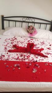 a bed with a bunch of red petals on it at Apartments Ira in Dubrovnik