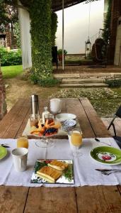 uma mesa de piquenique com comida e copos de sumo de laranja em Relax em Borgosesia