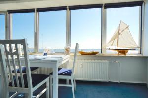 uma cozinha com uma mesa e um veleiro na janela em Ferienwohnung Schleiloge mit Panoramablick auf die Schlei em Schleswig
