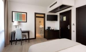 um quarto de hotel com uma cama e uma secretária com uma cadeira em Hotel Cartagena Puerto em Cartagena
