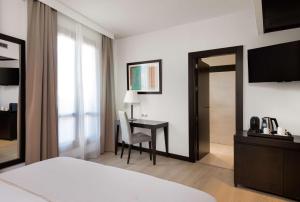 a hotel room with a desk and a bedroom at Hotel Cartagena Puerto in Cartagena