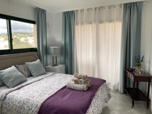 a teddy bear sitting on a bed in a bedroom at Marbella Cabopino golf and beach only Adults in Marbella
