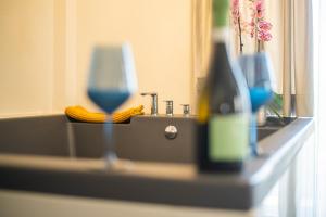 Pachia Ammos的住宿－Thronos Aqua Appartment 2，浴室柜台配有水槽和一瓶葡萄酒