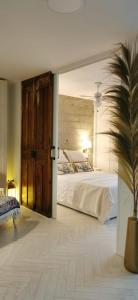 a bedroom with a large bed and a potted plant at Primera Línea Pau 5 - Playa de San Juan in Playa de San Juan