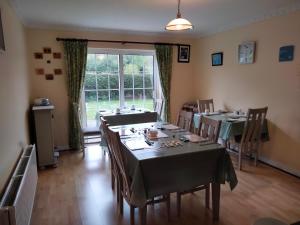 a dining room with tables and chairs and a window at Larkfield House B&B, Ballycasheen Kerry V93 WD51 in Killarney