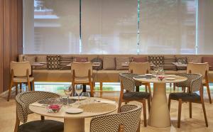 un restaurante con mesas y sillas y una gran ventana en NH Ciudad de Valencia, en Valencia
