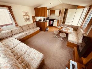 a living room with a couch and a table at Sea Wagon Caravan in Brixham
