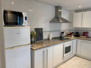 a kitchen with a white refrigerator and a microwave at Marbella Cabopino golf and beach only Adults in Marbella