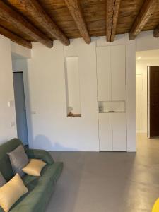salon z zieloną kanapą i białymi szafkami w obiekcie L’atelier di Porta Venezia w Mediolanie