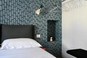sypialnia z łóżkiem i ścianą pokrytą tapetą w obiekcie L’atelier di Porta Venezia w Mediolanie