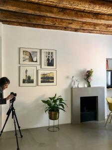 kobieta robiąca zdjęcie pokoju aparatem w obiekcie L’atelier di Porta Venezia w Mediolanie