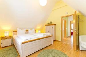 a bedroom with a large white bed and a bathroom at Ferienhaus Reethaus Koserow in Ostseebad Koserow