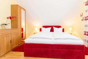 a bedroom with a large red bed in a room at Ferienhaus Reethaus Koserow in Ostseebad Koserow