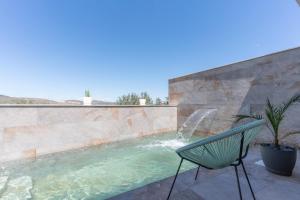 a green chair sitting next to a swimming pool at Villa Maria in Murcia