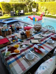 a picnic table with food and a swimming pool at Tavira independent suite with Pool at Casa Reflexos in Tavira