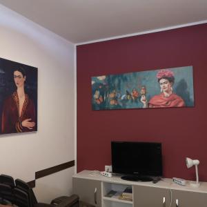 un soggiorno con 2 dipinti sul muro di Casa Frida a San Vito lo Capo