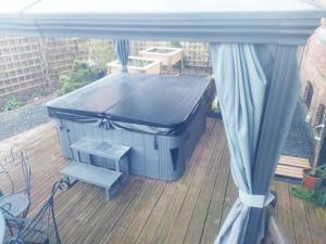 un conteneur bleu assis sur une terrasse avec un banc dans l'établissement L'Antre de Gadag, à Forges-les-Eaux