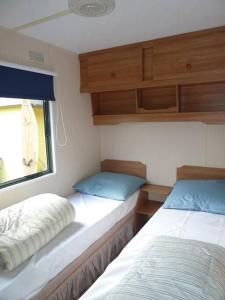 een slaapkamer met 2 bedden en een raam bij Chalet K2 op de Holle Poarte te Makkum in Makkum
