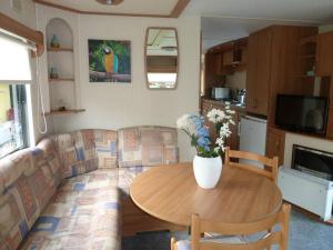 een woonkamer met een tafel en een bank bij Chalet K2 op de Holle Poarte te Makkum in Makkum