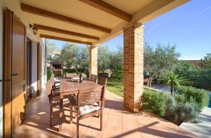 a patio with a wooden table and chairs on a porch at Villa Rustika in Dobrinj