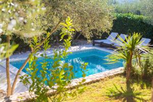 a swimming pool in a garden with a bench next to it at Villa Rustika in Dobrinj